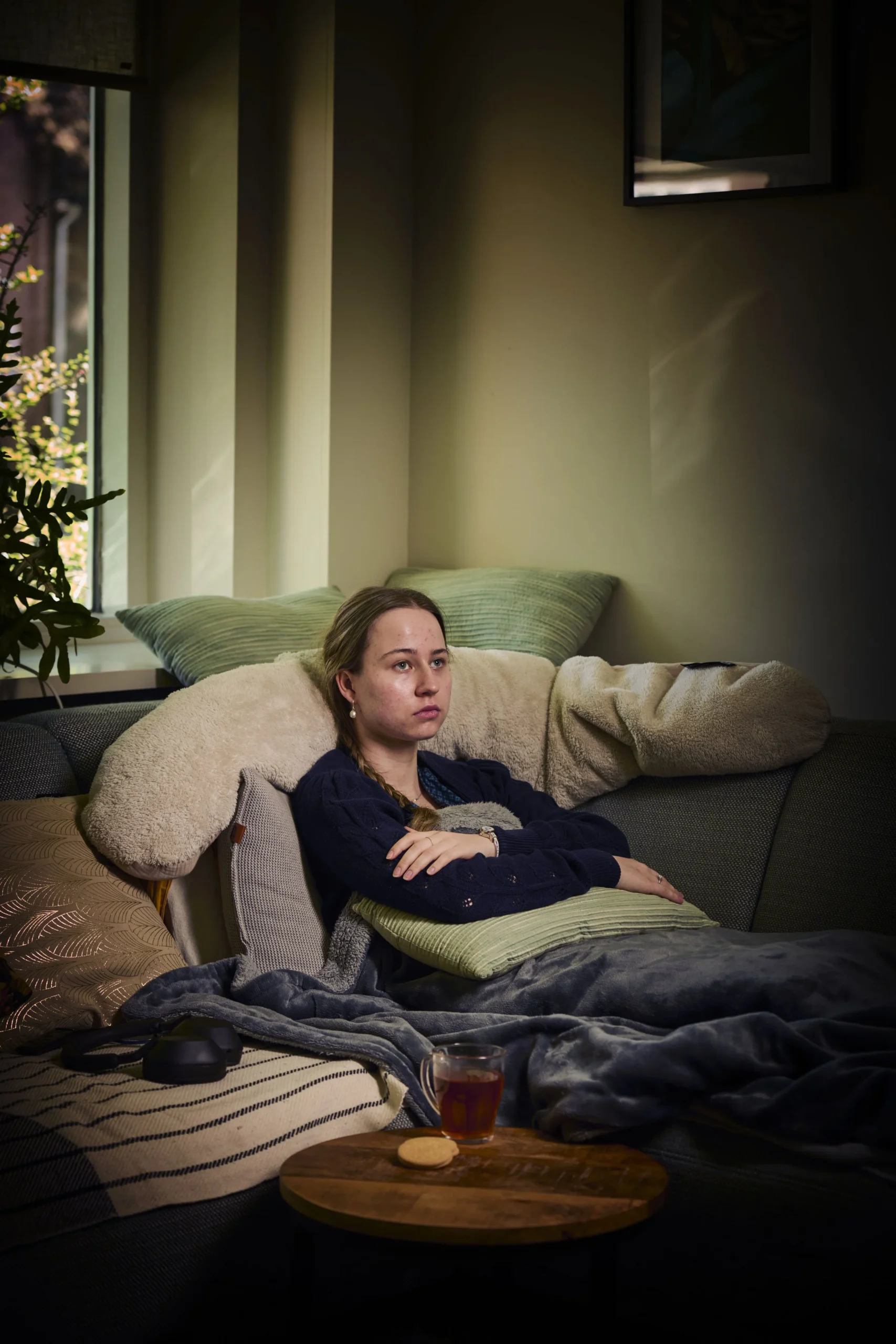 Mette, een Long COVID patiënt, rustend op de bank.