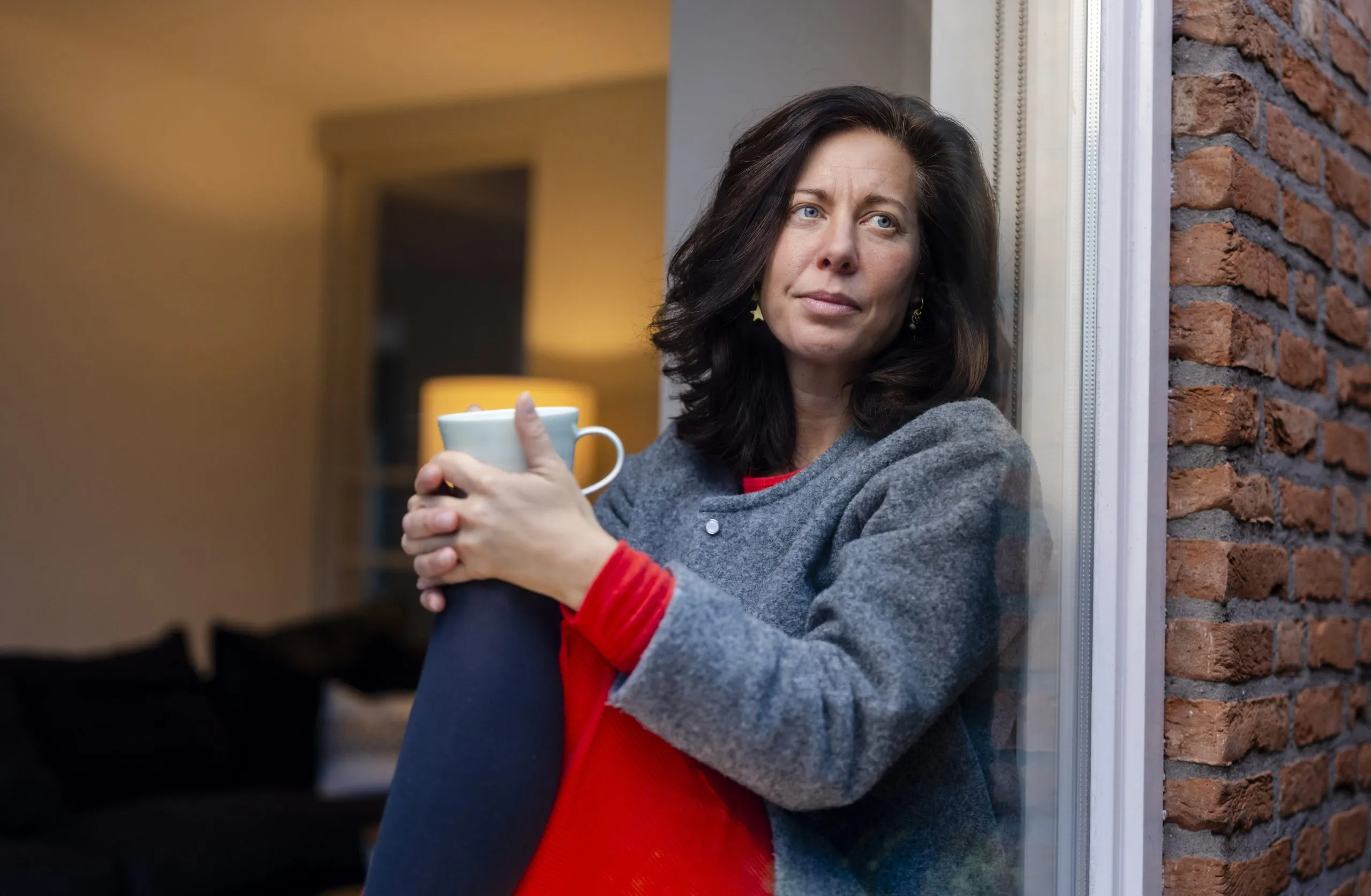 Sabine, een Long COVID patiënt, achter het raam.